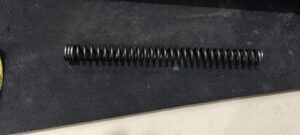 Old spring with 3 collapsed coils creating effectively a piston weight and increasing felt recoil